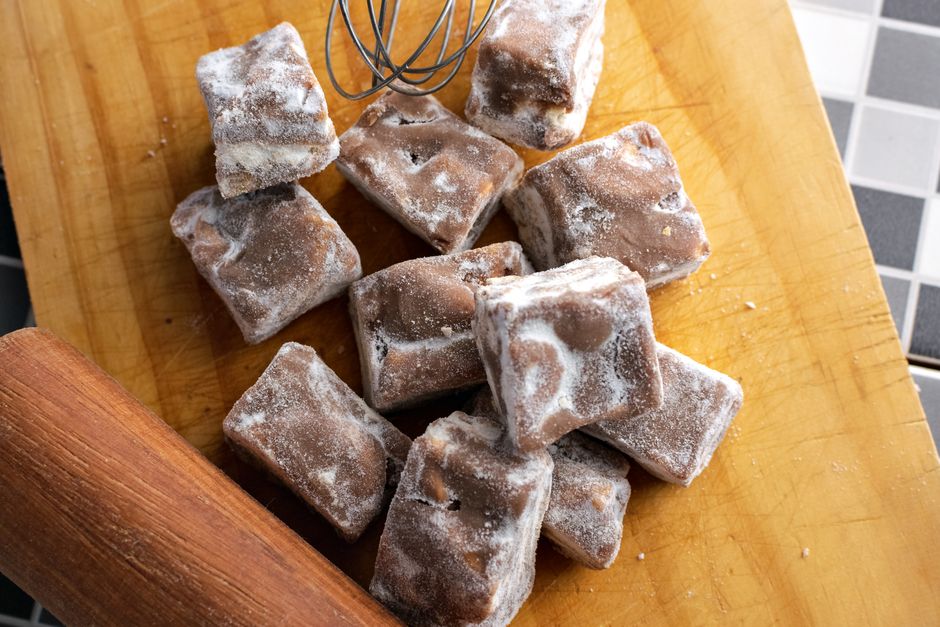 Cubos de açúcar mascavo e de açúcar branco sobre uma superfície de madeira