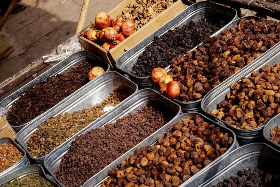 Frutas secas variadas incluindo uva-passa, damasco e figo sobre superfície de madeira