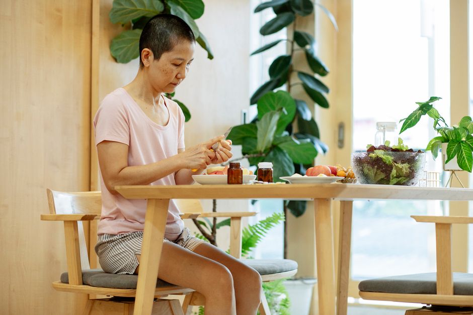Mulher preparando salada colorida com frutas e vegetais ricos em fibras