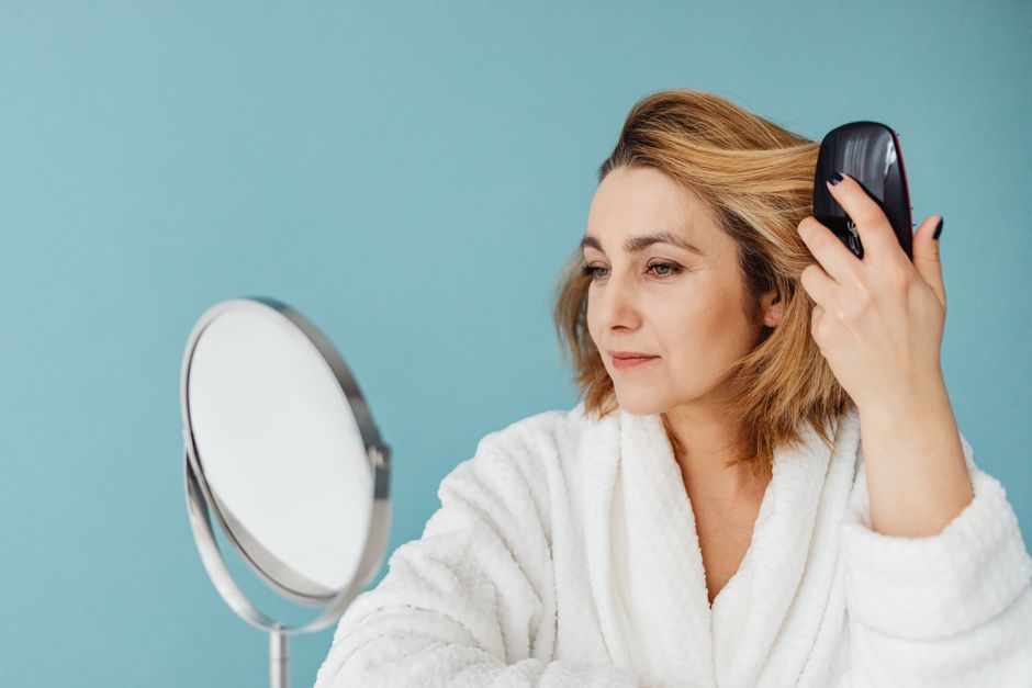 Mulher cuidando dos cabelos brancos com produtos específicos de proteção