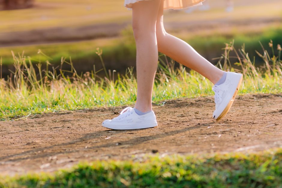 Mulher caminhando ao ar livre em um dia de exercício, vista das pernas