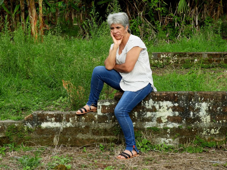 Mulher de meia-idade com expressão de preocupação, mão na testa, refletindo sobre esquecimento