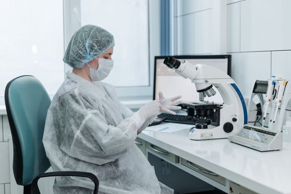 Técnico de laboratório analisando células de sangue ao microscópio