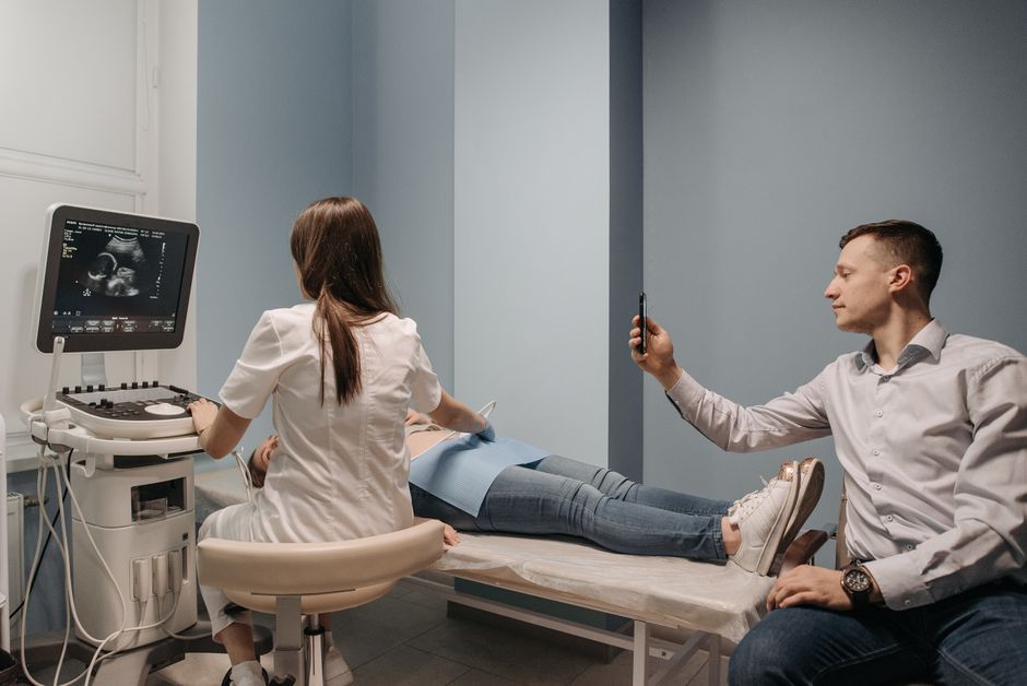 Médico angiologista realizando ultrassom nas pernas para diagnosticar inchaço
