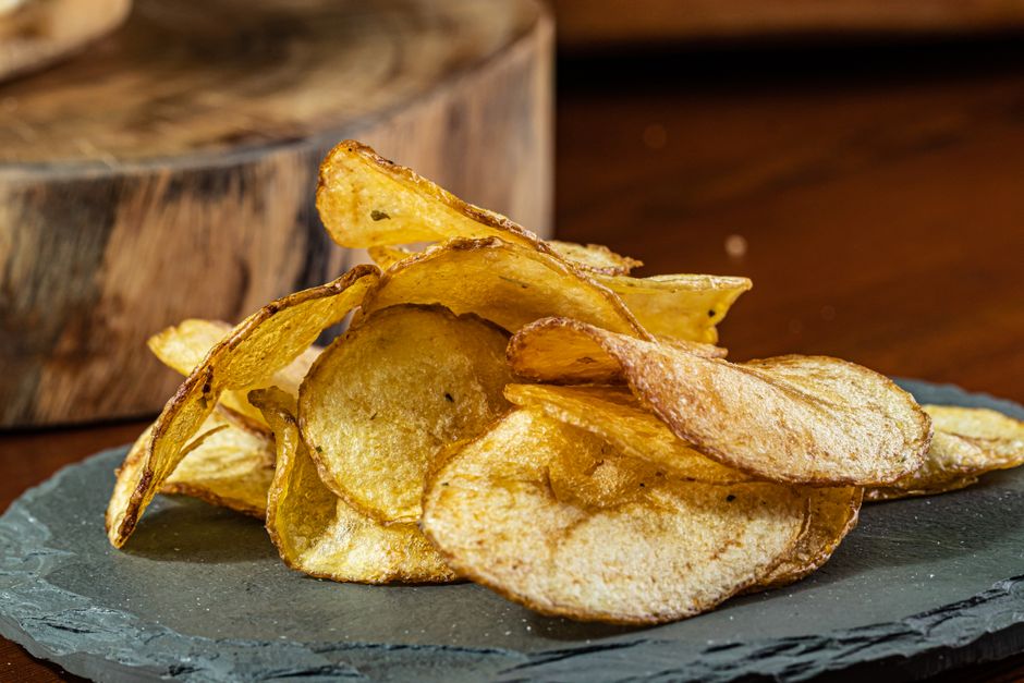 Chips de batata-doce crocantes caseiros servidos em prato branco