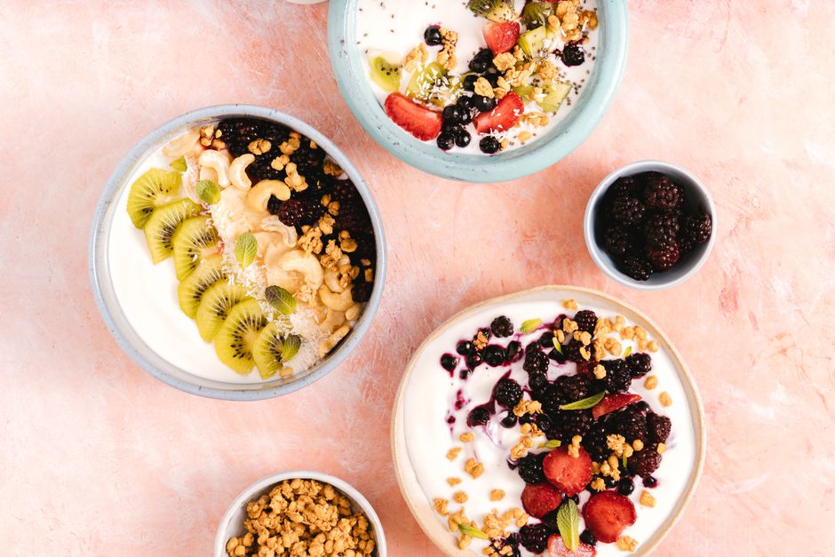 Tigela com lanche saudável contendo oleaginosas, frutas frescas e iogurte natural