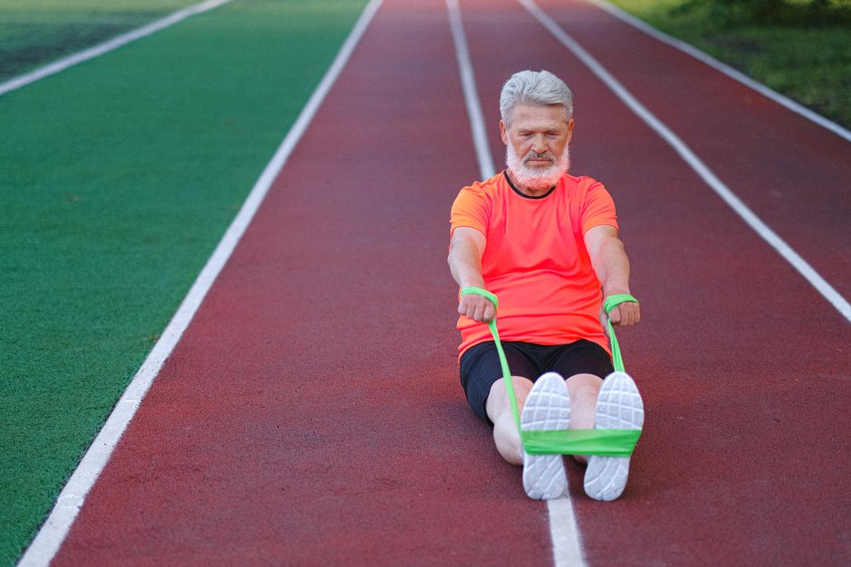 Homem mais velho faz exercício com faixa elástica