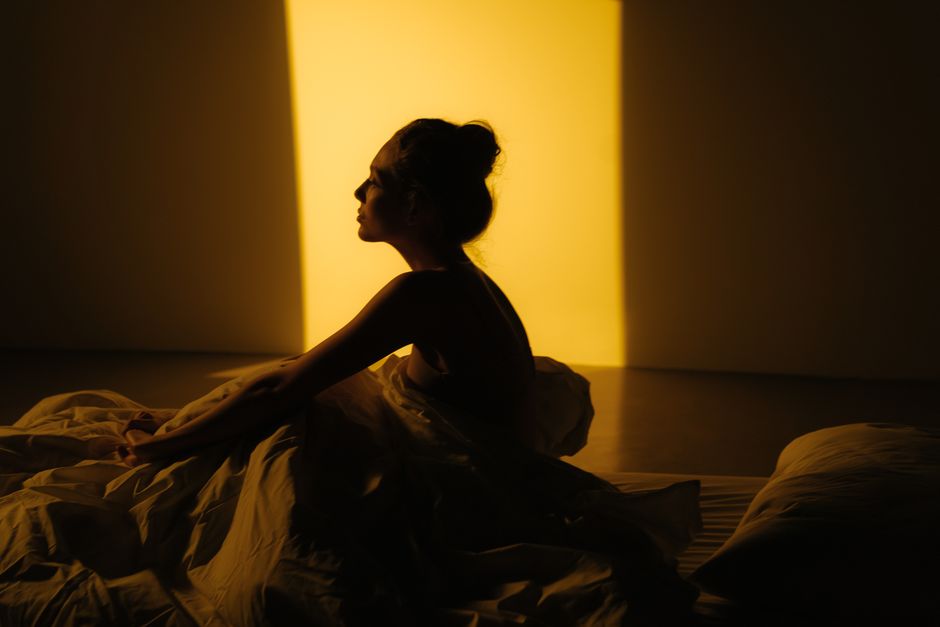 Mulher meditando na cama antes de dormir para relaxar